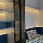 Completed bedroom with smoked-glass tall unit, LED-lit floating shelves and upholstered daybed by TSC Design Studio