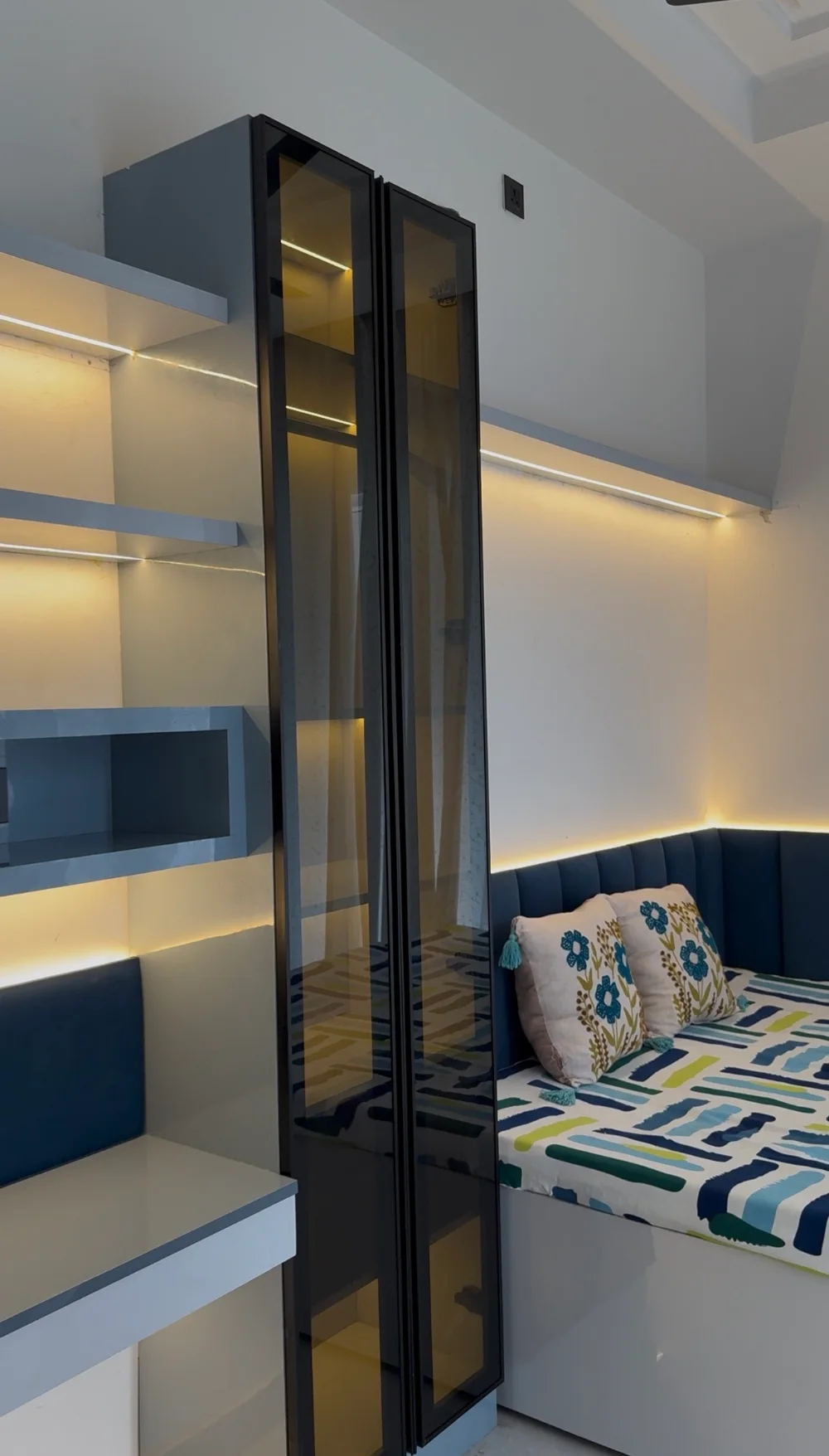 Completed bedroom with smoked-glass tall unit, LED-lit shelves and upholstered daybed by TSC Design Studio